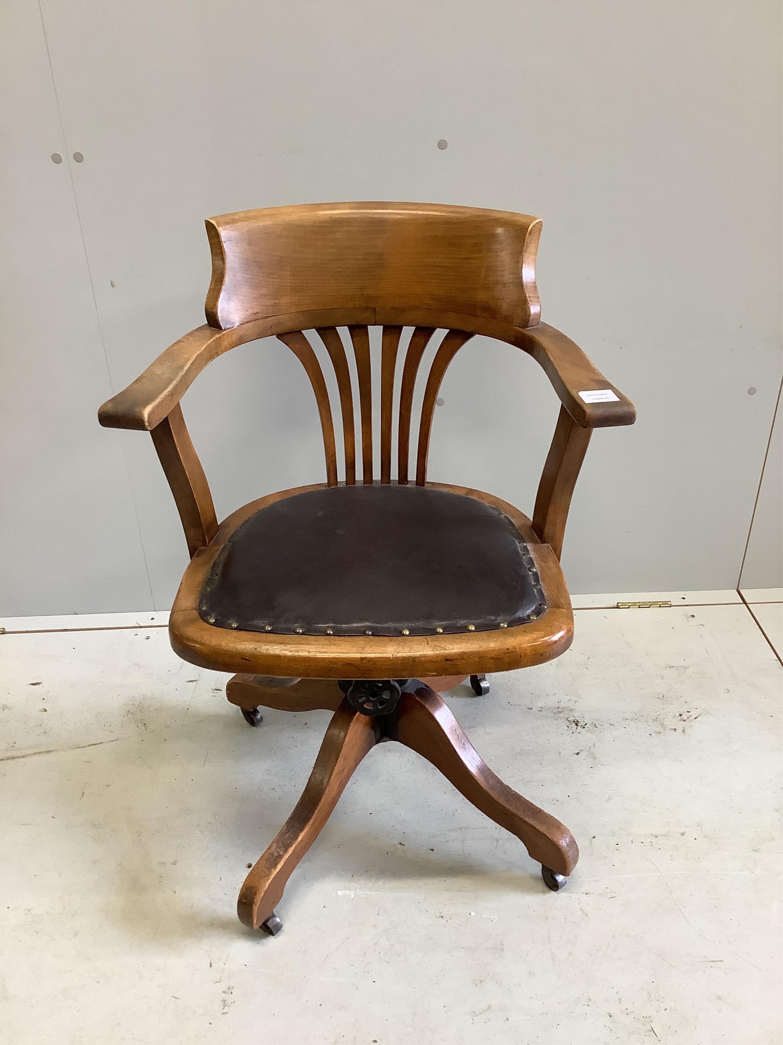 An Edwardian stained beech revolving desk chair, width 62cm. Condition - faded, otherwise good